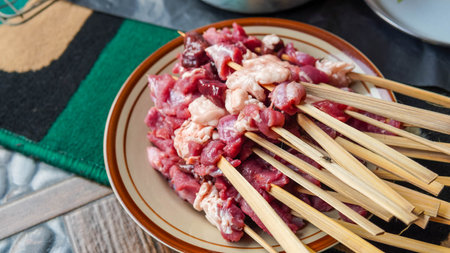 Skewers of pork in a plate on a wooden tableの写真素材