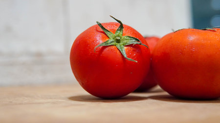 Ripe red tomatoes on a wooden table, close-up.の写真素材