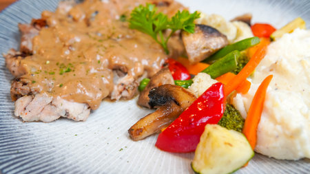 chicken fillet with mushrooms and vegetables on a white plate.の写真素材