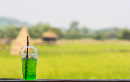 Green soda in cup on nature backgroundの写真素材