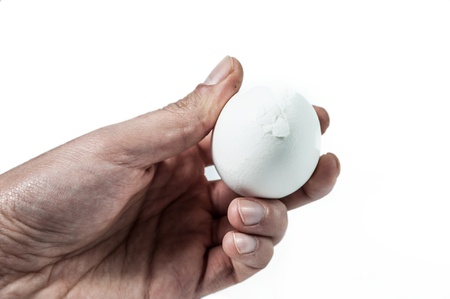 Dirty hand with cracked egg isolated on whiteの写真素材