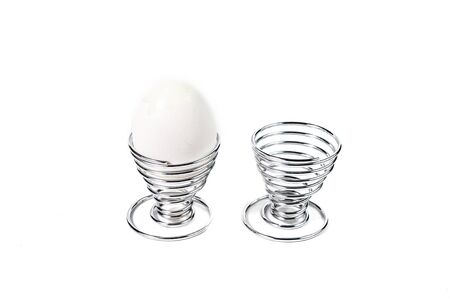 Egg in Spiral Silver Egg Cup on White Backgroundの写真素材