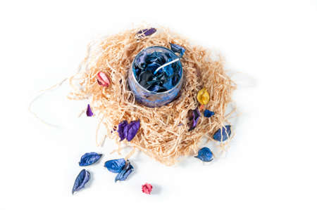 Gift homemade candle on decorative straw isolated on white backgroundの写真素材