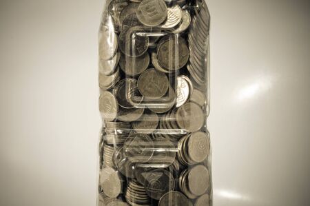 Fragment of plastic bottle with coins, vintage effectの写真素材