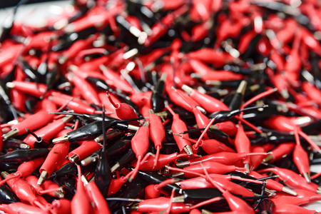 Heap of black and red copper clamps for battery chargingの写真素材