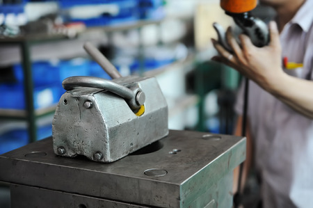 Worker mounting the press form at CNC workshop, closeupの写真素材