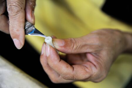 Closeup of worker's hands carving a plastic detailの写真素材