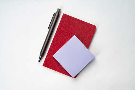 Top view of white table with notebook, calculator, pen and sticky noteの写真素材