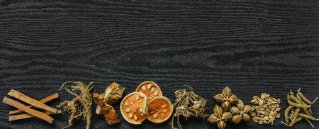Dried herbs and Ginseng, Top view of Thai herbs and ginseng on wooden floor. Slices of dries root for make a herb juice on the dark table.の写真素材