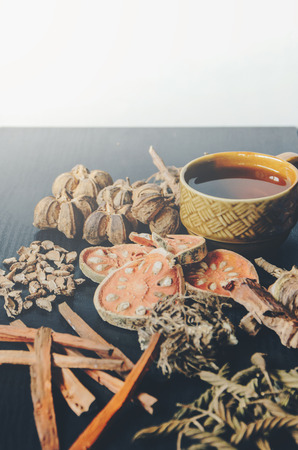Dried herbs and Ginseng, Close-up of Thai herbs and ginseng on wooden floor. Slices of dries root for make a herb juice on the dark table.の写真素材