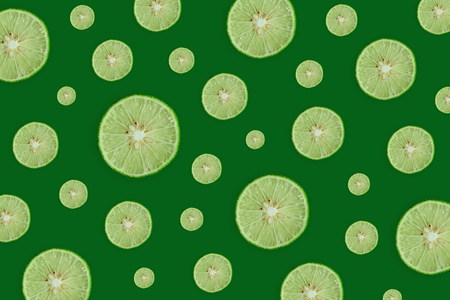 Close up of green lemon or lime on the green background, Fresh lemon(lime) slice and sour fruit or...