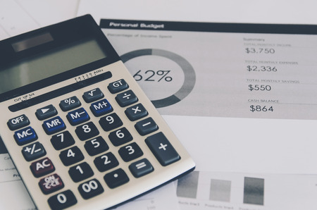 Show the business concept of financial and accounting, Finance report and calculator with paper sheet of planning data and analyze graph and chart on the table.の写真素材
