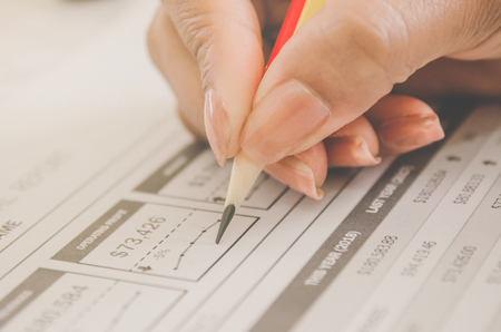 Business concept of financial and accounting with human hand are pointing on paper sheet and writing, Finance report and with paper sheet of planning data and analyze graph and chart on the table.の写真素材