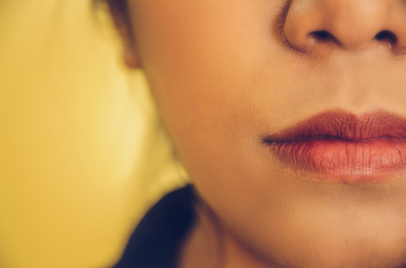 Beauty face of Asian women by applying lipstick on mouth, The girl is makeup her face with lipstick, Soft and smooth face skin by cosmetics and foundation and using makeup brush on the face.の写真素材