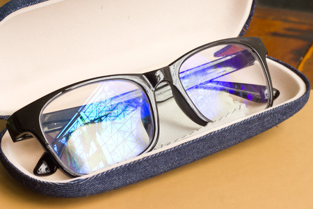 Glasses on notebook  on wood background.の写真素材