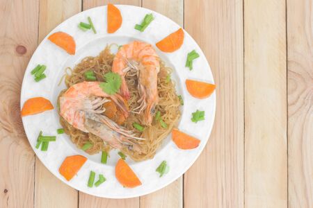 Shrimp with vermicelli in dish on wood table.の写真素材