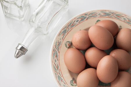 brown eggs and clear bottle on white background