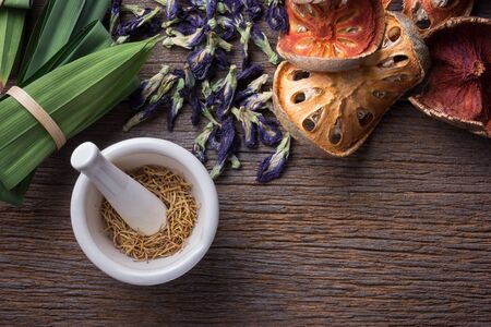 Mortar and pestle with herb on grunge wood tableの写真素材