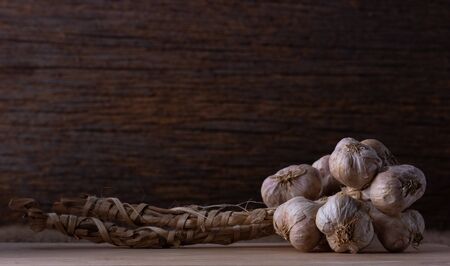 group of garlic head on wooden background , low light.