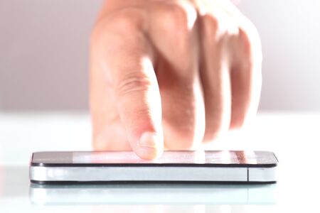 Hand using smartphone that is placed on the desk