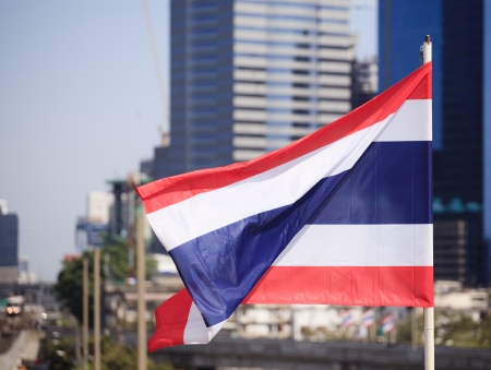 National flag of Thailand with a city background