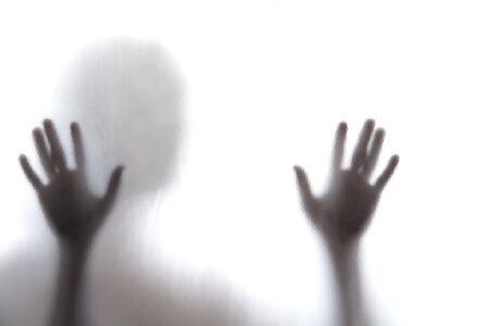 Shadow of men standing behind frosted glassの写真素材