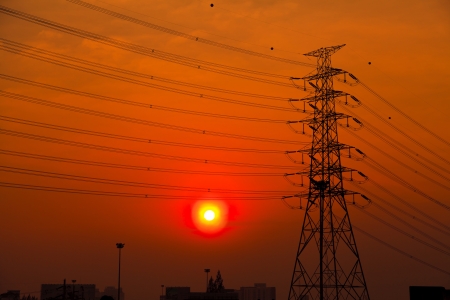 Silhouette of high voltage towers at sunsetの写真素材