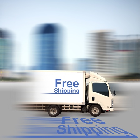 White van with Free Shipping and office buildings in the cityの写真素材