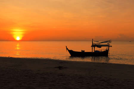 Silhouette of fishing boat at sunsetの写真素材