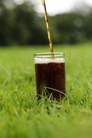 Cola pouring in a glass in outdoorの写真素材