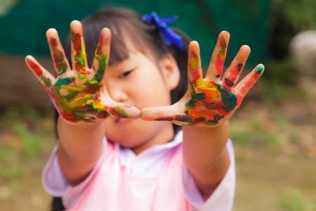 Little girl with hands painted in colorful paint の写真素材