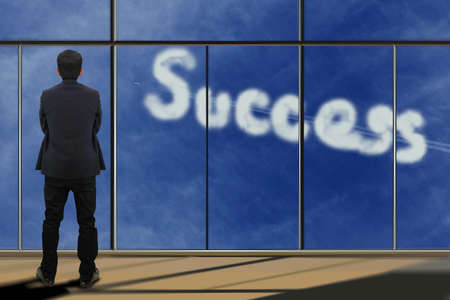 Businessman looking through window with successの写真素材