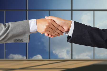 Business people handshaking on background of modern officeの写真素材