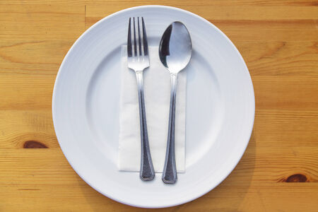 Fork and spoon and plate on tableの写真素材