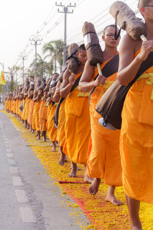 BANGKOK,THAILAND-JAN 27 : Row of Buddhist hike Thai monks on streets strewn with marigold petals on the Thammachai hike establish the path of the great teachers on January 27, 2014 in Bangkok, Thailandのeditorial素材