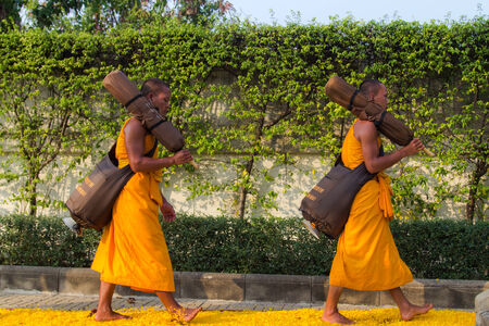BANGKOK,THAILAND-JAN 27 : Row of Buddhist hike Thai monks on streets strewn with marigold petals on the Thammachai hike establish the path of the great teachers on January 27, 2014 in Bangkok, Thailandのeditorial素材