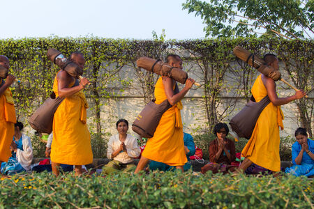 BANGKOK,THAILAND-JAN 27 : Row of Buddhist hike Thai monks on streets strewn with marigold petals on the Thammachai hike establish the path of the great teachers on January 27, 2014 in Bangkok, Thailandのeditorial素材