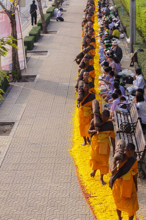 BANGKOK,THAILAND-JAN 27   Row of Buddhist hike Thai monks on streets strewn with marigold petals on the Thammachai hike establish the path of the great teachers on January 27, 2014 in Bangkok, Thailandのeditorial素材