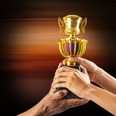 Hands holding golden trophyの写真素材