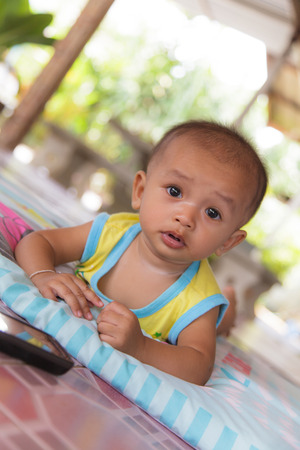 Portrait of a crawling baby on the bedの写真素材