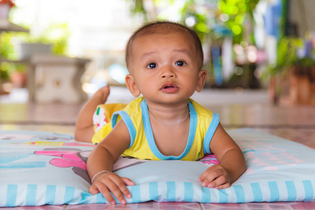 Portrait of a crawling baby on the bedの写真素材