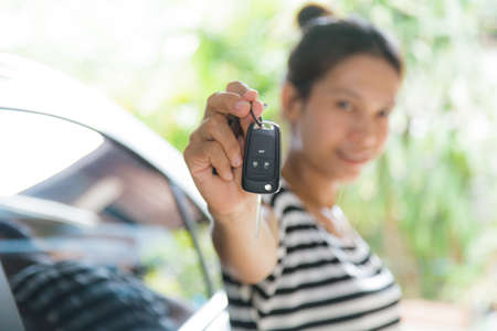 Woman holding a car key with carの写真素材