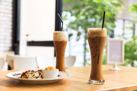 Iced coffee and eclairs filled with ice creamの写真素材