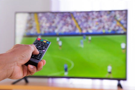 Watching tv and hand pressing remote control