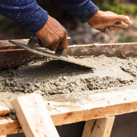 Construction workers at a construction site,  hand using smooth the cement screed with trowel の写真素材