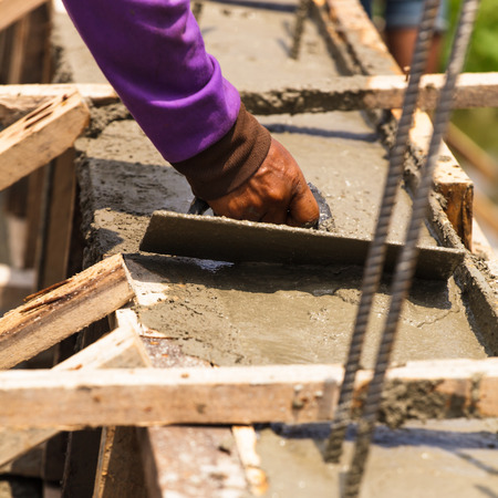 Construction workers at a construction site,  hand using smooth the cement screed with trowel の写真素材