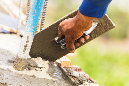 Construction workers at a construction site,  hand using smooth the cement screed with trowel の写真素材