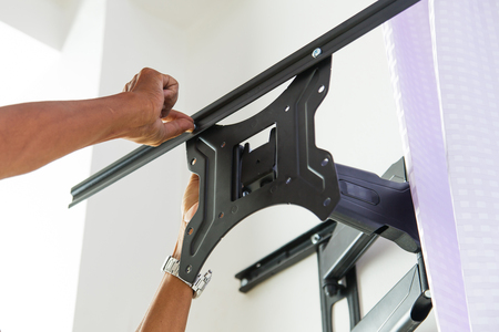 Man installing mount TV on the wall at homeの写真素材