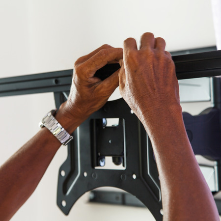 Man installing mount TV on the wall at homeの写真素材