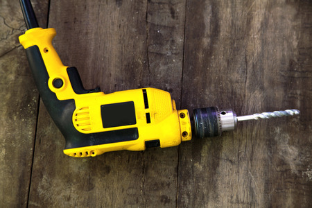 Drilling machine on wood background